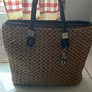 This is a Brighton straw tote bag with leather trim
